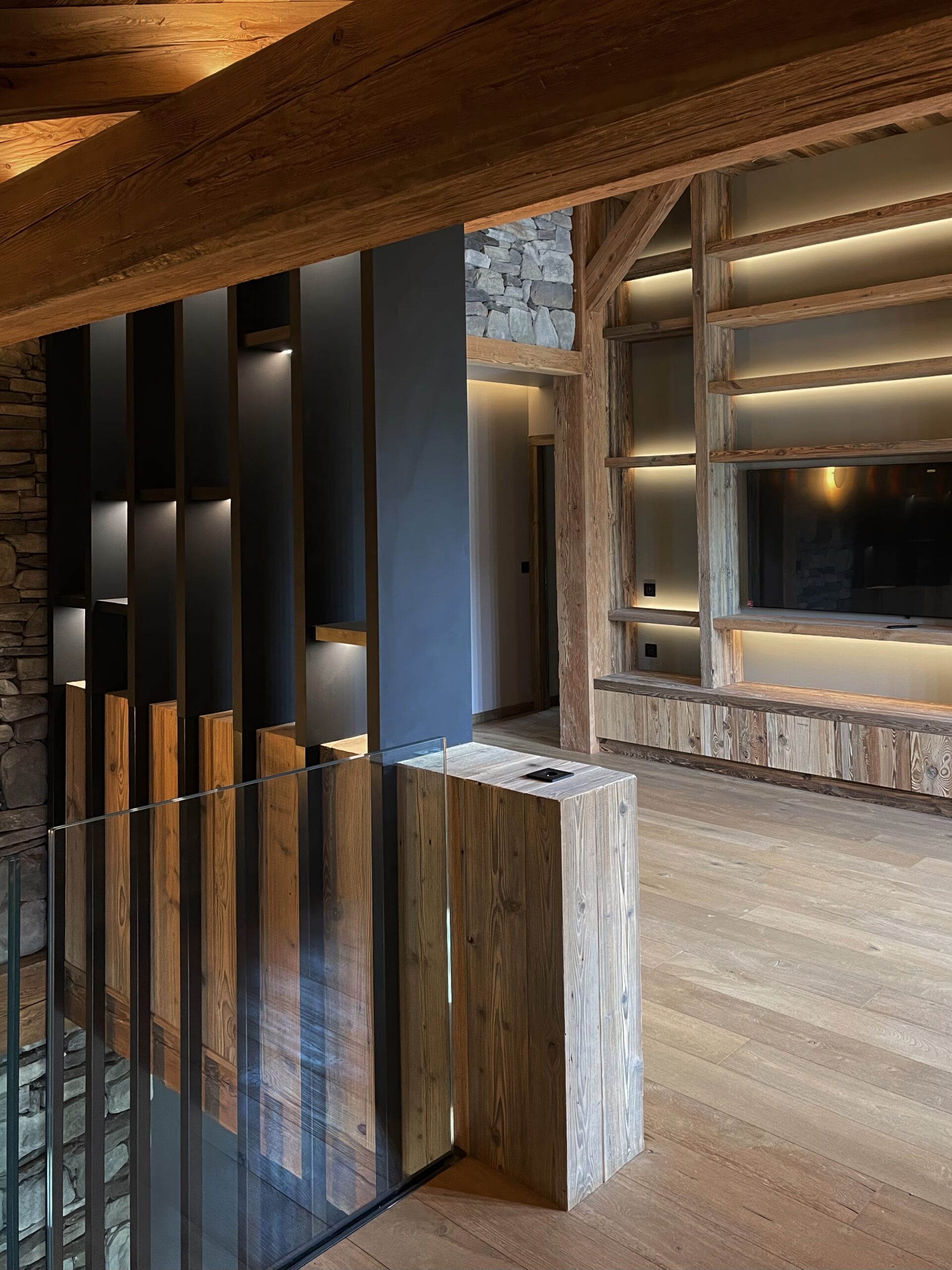 Architecture d'intérieur luxe chalet à Megève avec aménagement bibliothèque et meuble tv en bois