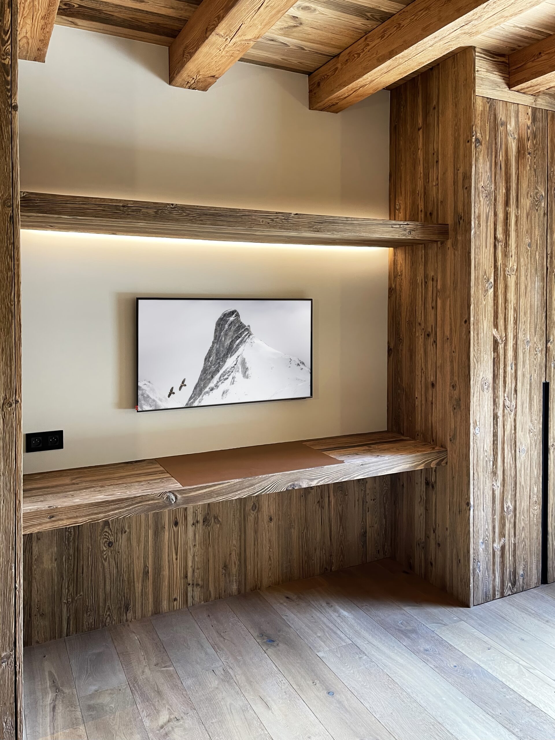 Architecture d'intérieur chalet contemporain avec mobilier sur mesure en bois vieilli et éclairage intégré