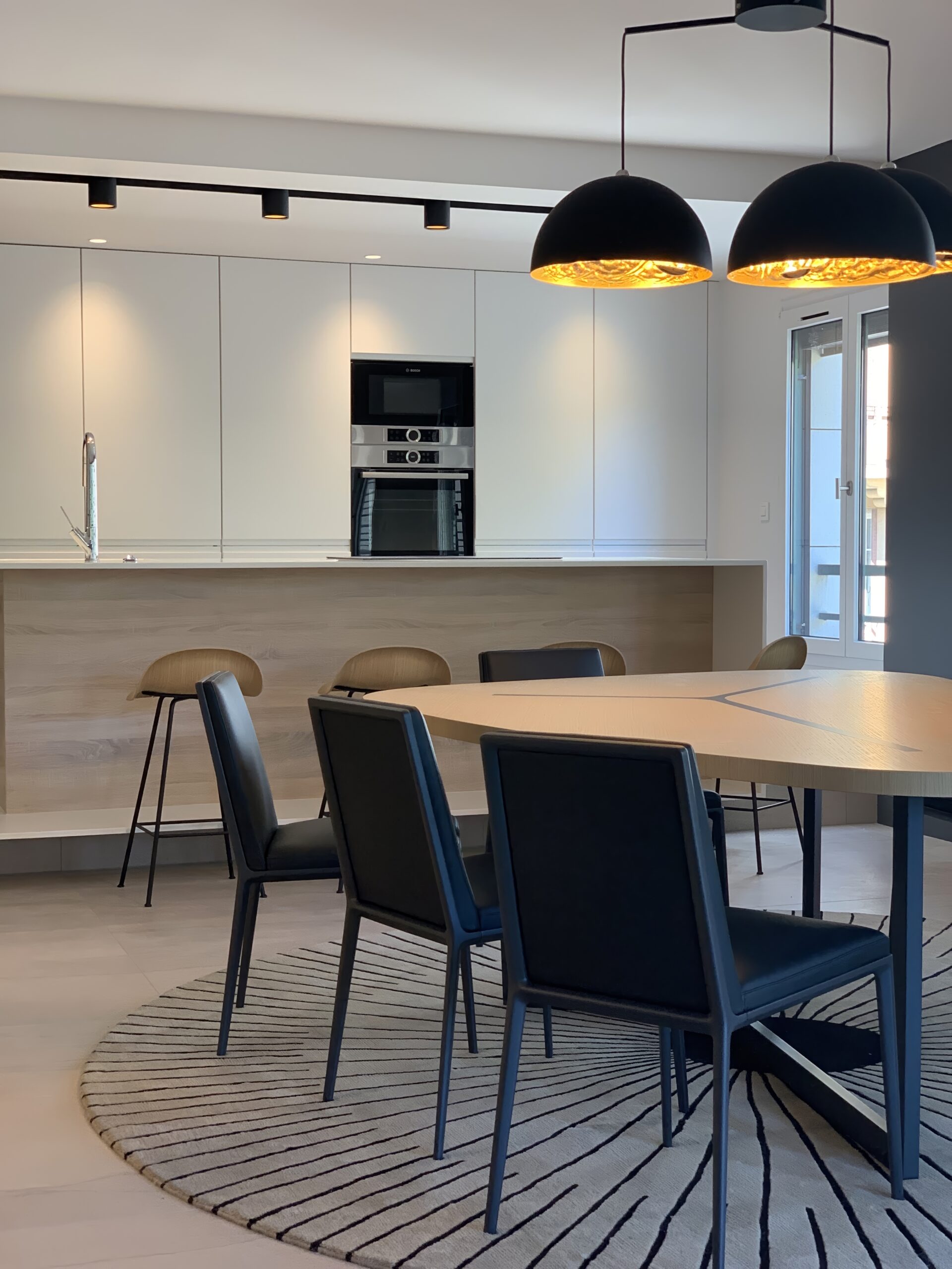 Agencement de mobilier contemporain à Lyon avec cuisine sur mesure et ilot central en Corian blanc