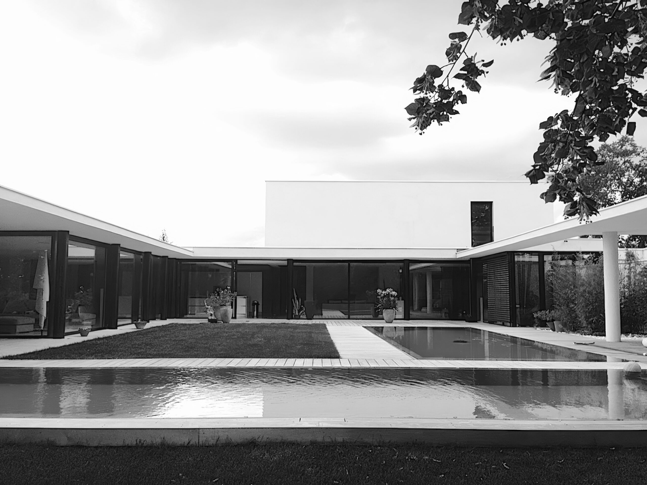 Maison d'architecte d'exception à Lyon avec patio, double piscine miroir et grandes menuiseries aluminium noir et brises-soleil orientables